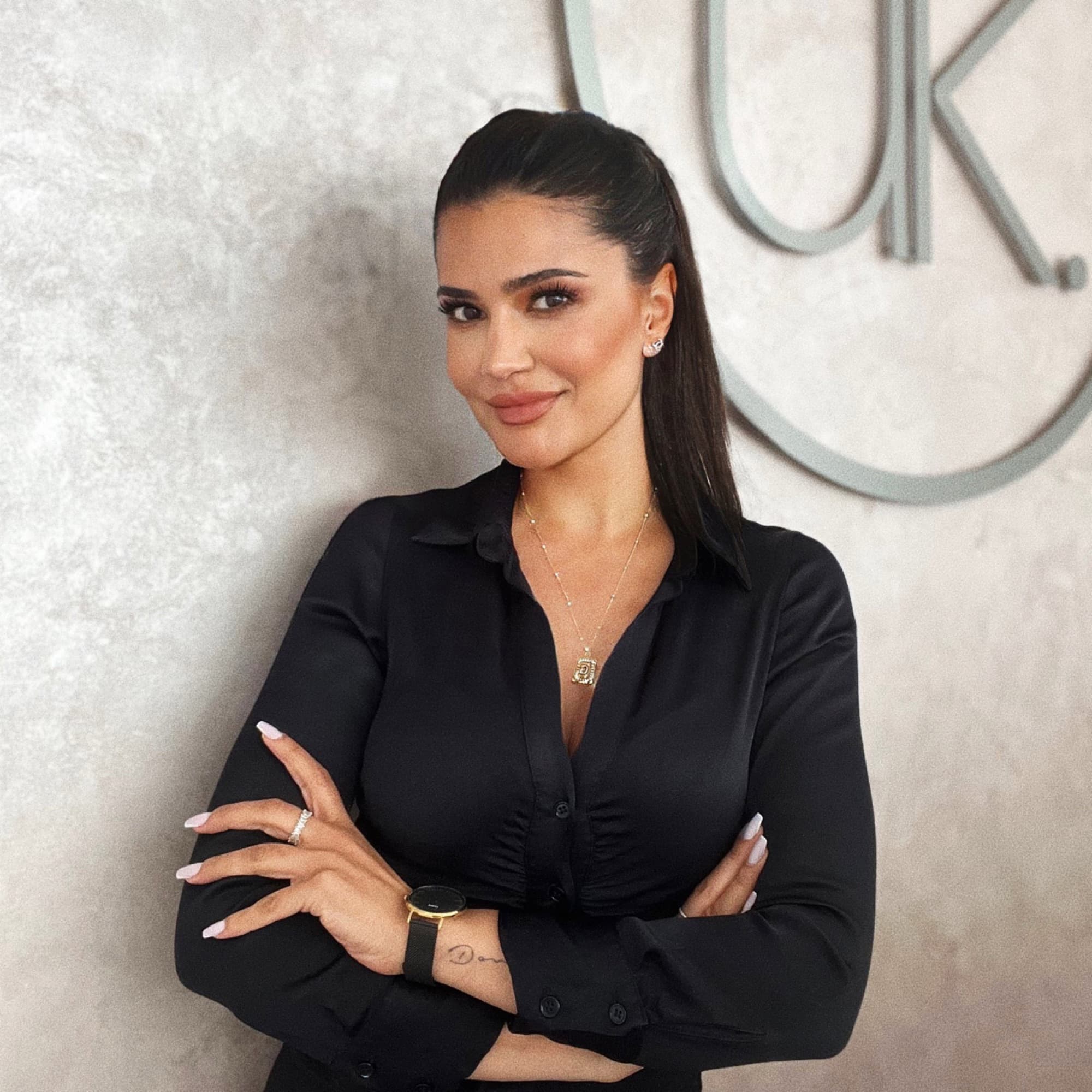 Ülker Karataş, Fachkosmetikerin und Inhaberin der UK Kosmetik Academy, vor dem Studio-Logo